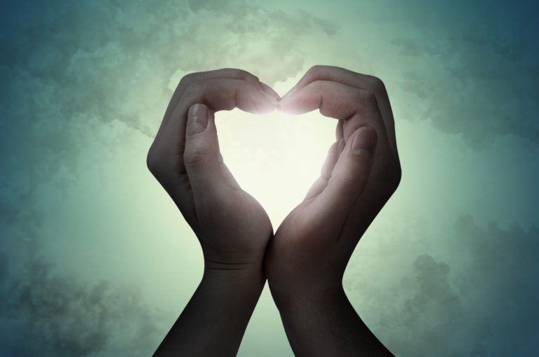 Mains formant un cœur de lumière – symbole d’engagement mutuel